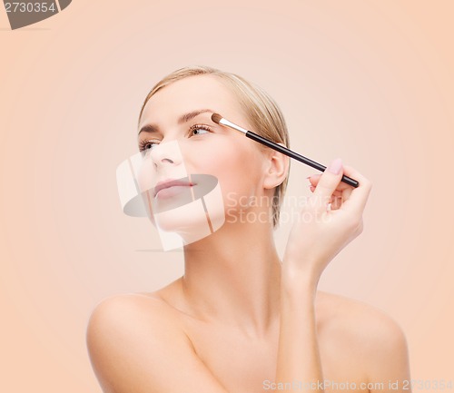 Image of beautiful woman with makeup brush