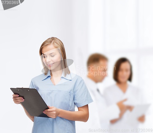 Image of smiling female doctor or nurse with clipboard