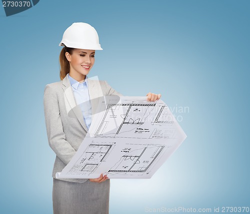 Image of smiling architect in white helmet with blueprints