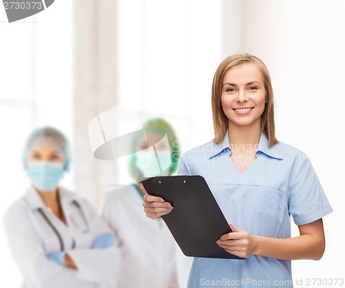 Image of smiling female doctor or nurse with clipboard