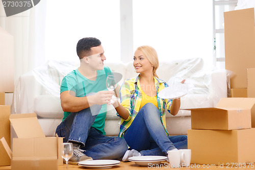 Image of smiling couple unpaking boxes with kitchenware