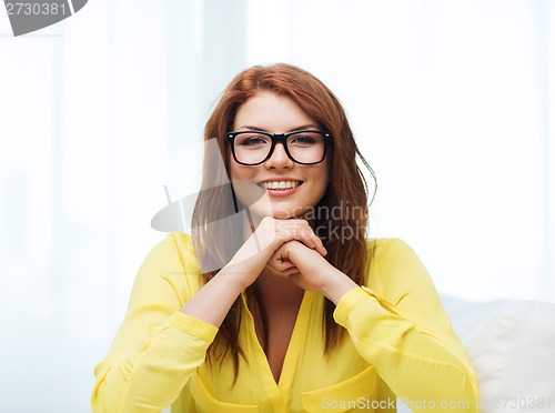 Image of smiling teenage girl in eyeglasses at home