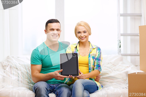 Image of couple relaxing on sofa with tablet pc in new home