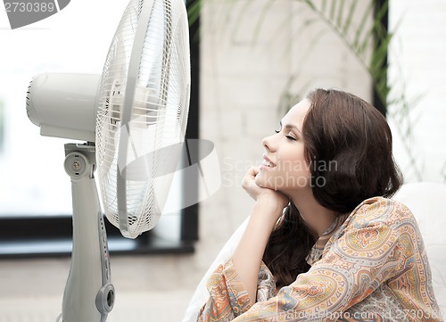 Image of happy and smiling woman sitting near ventilator