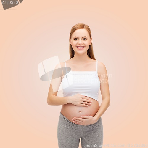 Image of happy future mother touching her belly