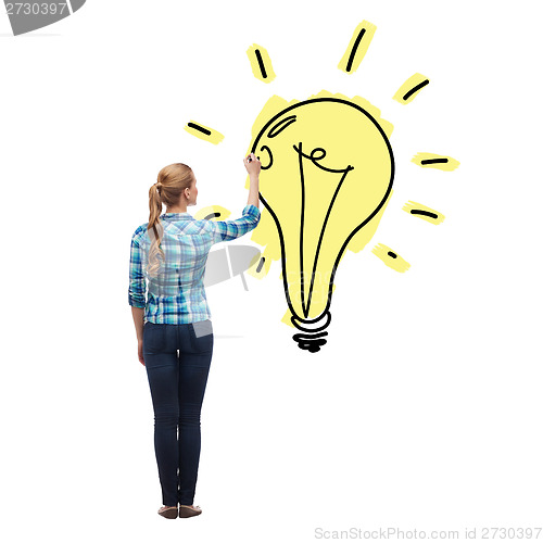 Image of woman from the back drawing light bulb in the air