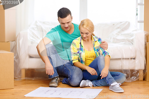 Image of smiling couple looking at bluepring in new home