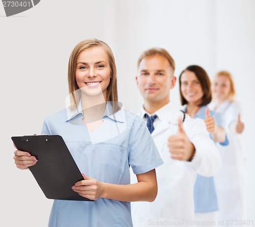 Image of smiling female doctor or nurse with clipboard