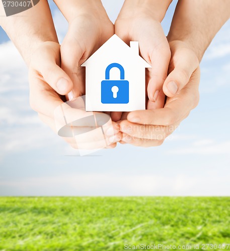 Image of hands holding paper house with lock