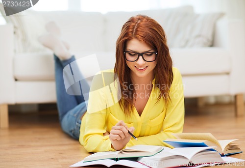 Image of smiling student girl reading books at home