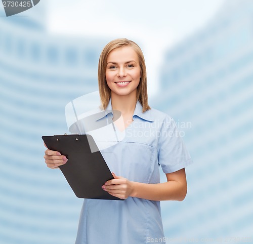 Image of smiling female doctor or nurse with clipboard