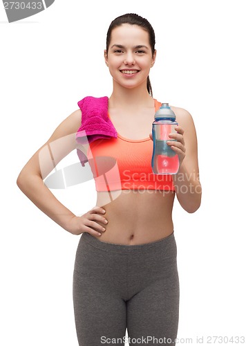 Image of sporty woman with towel and water bottle