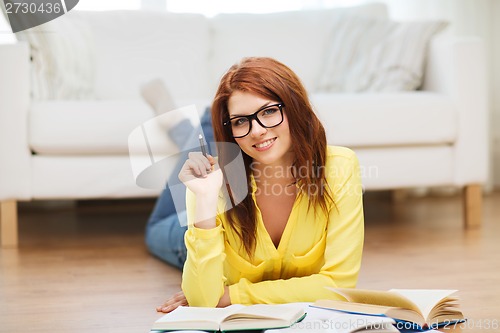 Image of smiling student girl reading books at home