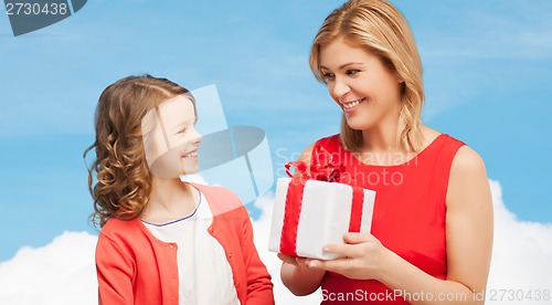 Image of smiling mother and daughter with gift box