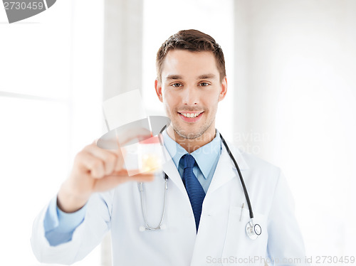 Image of male doctor with jar of capsules