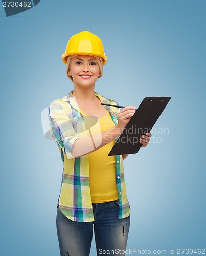 Image of smiling woman in helmet with clipboard