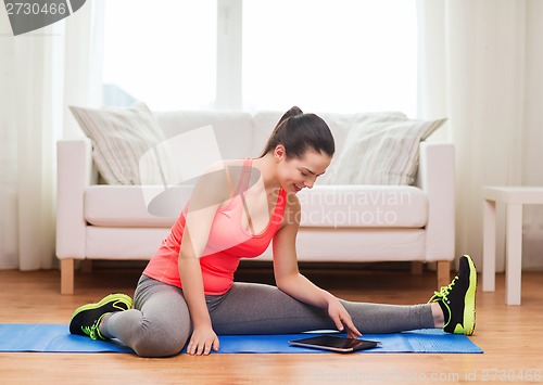 Image of smiling teenage girl streching on floor at home