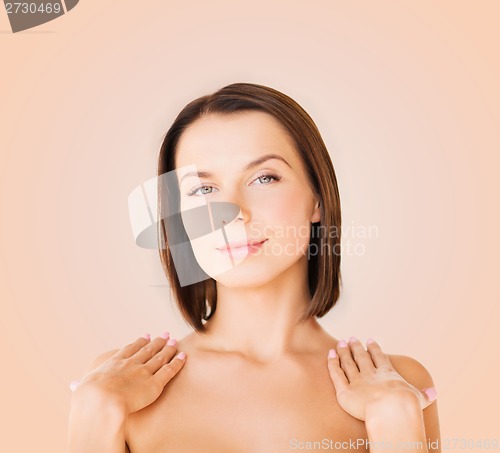 Image of beautiful woman touching her shoulders