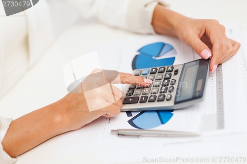 Image of businesswoman working with calculator in office