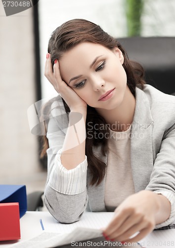 Image of bored and tired woman behid the table