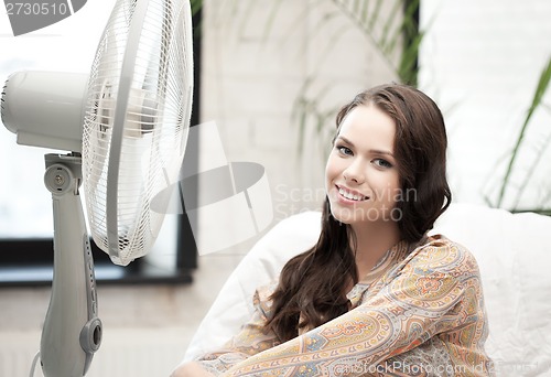 Image of happy and smiling woman sitting near ventilator