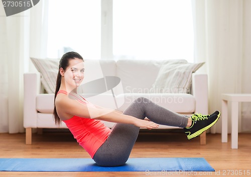 Image of smiling girl doing exercise on floor at home