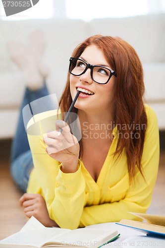 Image of smiling student girl reading books at home