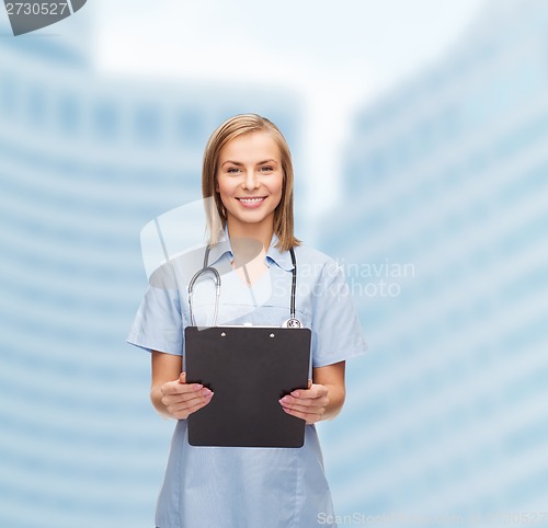 Image of smiling female doctor or nurse with clipboard