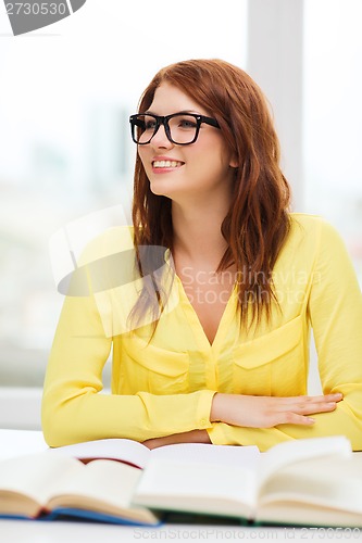 Image of smiling student girl with books in college