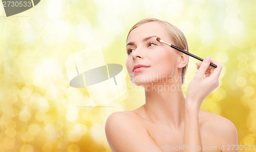 Image of beautiful woman with makeup brush