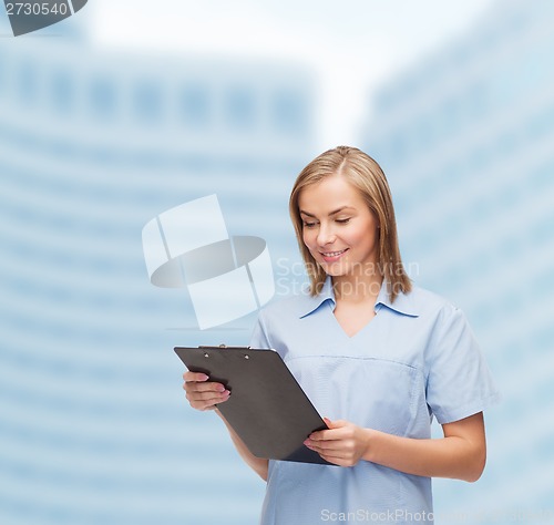 Image of smiling female doctor or nurse with clipboard