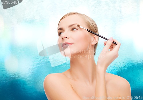 Image of beautiful woman with makeup brush