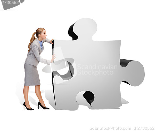 Image of busy businesswoman pushing puzzle piece