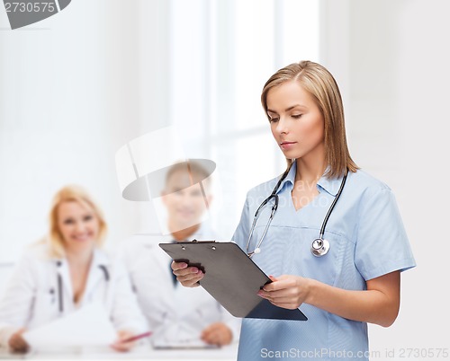 Image of smiling female doctor or nurse with clipboard