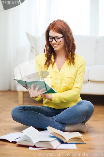 Image of smiling student girl reading books at home