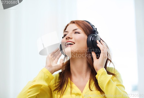 Image of smiling young girl in headphones at home