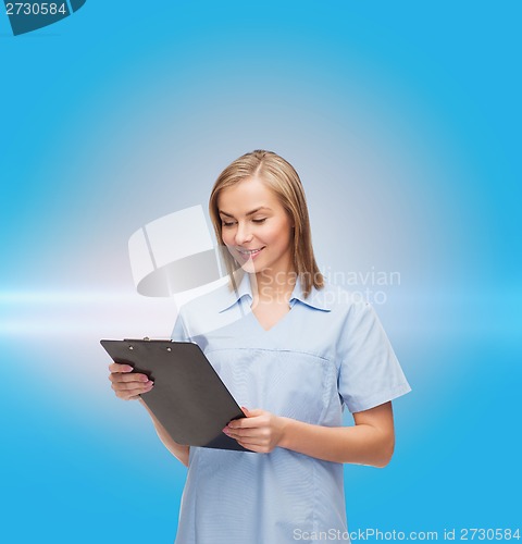 Image of smiling female doctor or nurse with clipboard