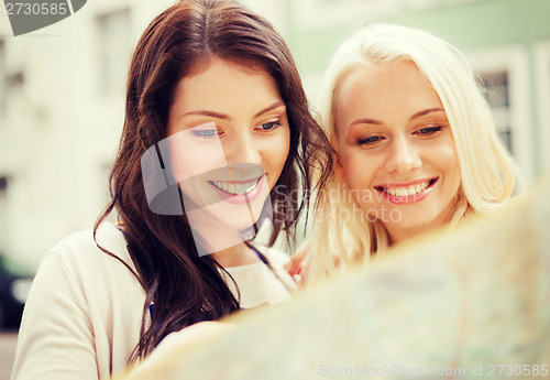 Image of beautiful girls looking into tourist map in city