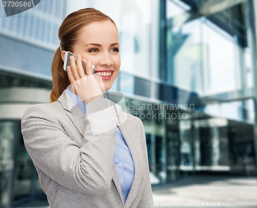 Image of young smiling businesswoman with smartphone