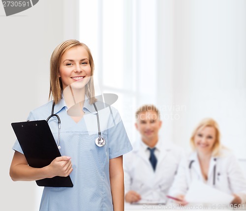 Image of smiling female doctor or nurse with clipboard