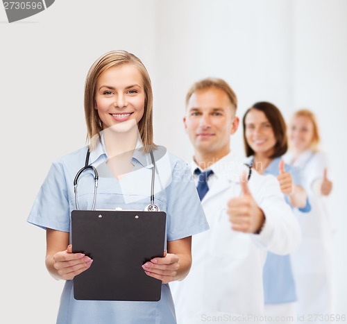 Image of smiling female doctor or nurse with clipboard