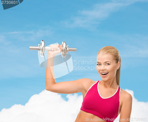 Image of smiling woman with heavy steel dumbbell