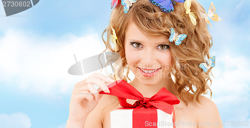 Image of teenager with butterflies in hair opening present