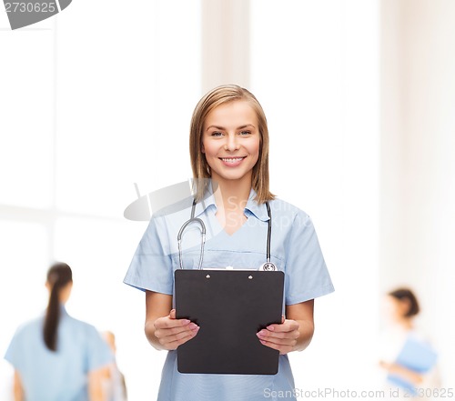 Image of smiling female doctor or nurse with clipboard