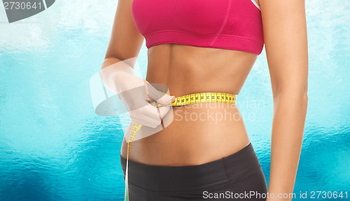 Image of close up trained belly with measuring tape