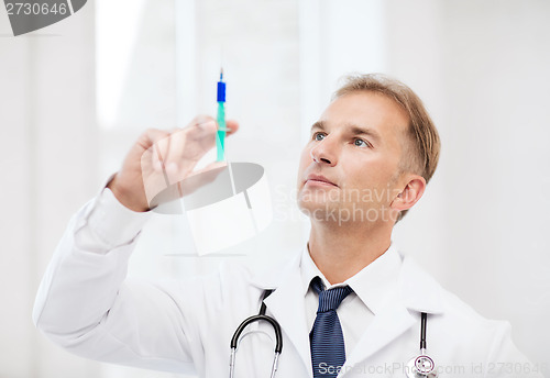 Image of male doctor holding syringe with injection