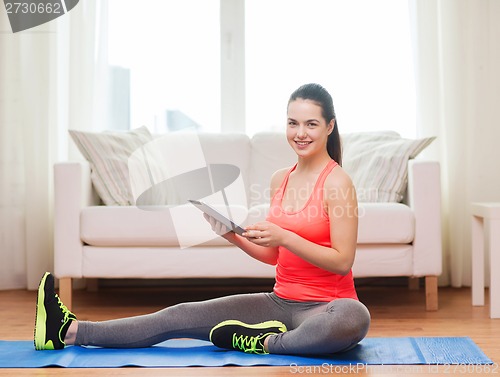 Image of smiling teenage girl streching on floor at home