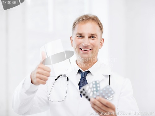 Image of male doctor with packs of pills