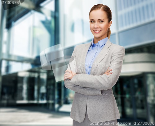 Image of young smiling businesswoman with crossed arms