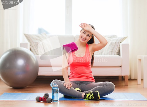 Image of smiling girl with bottle of water after exercising